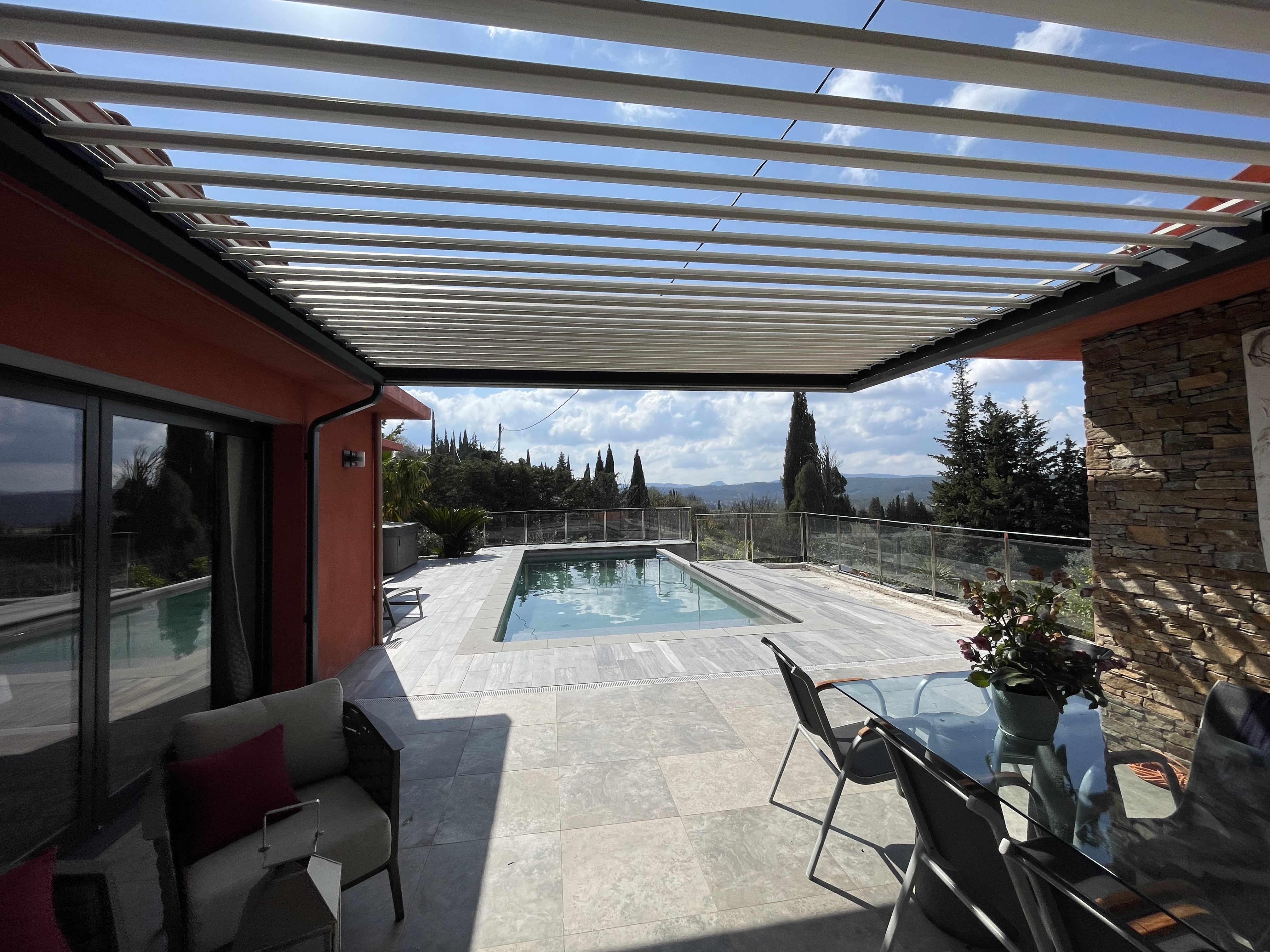 Pergola bioclimatique aluminium avec piscine et vue panoramique, réalisation Wooden Key