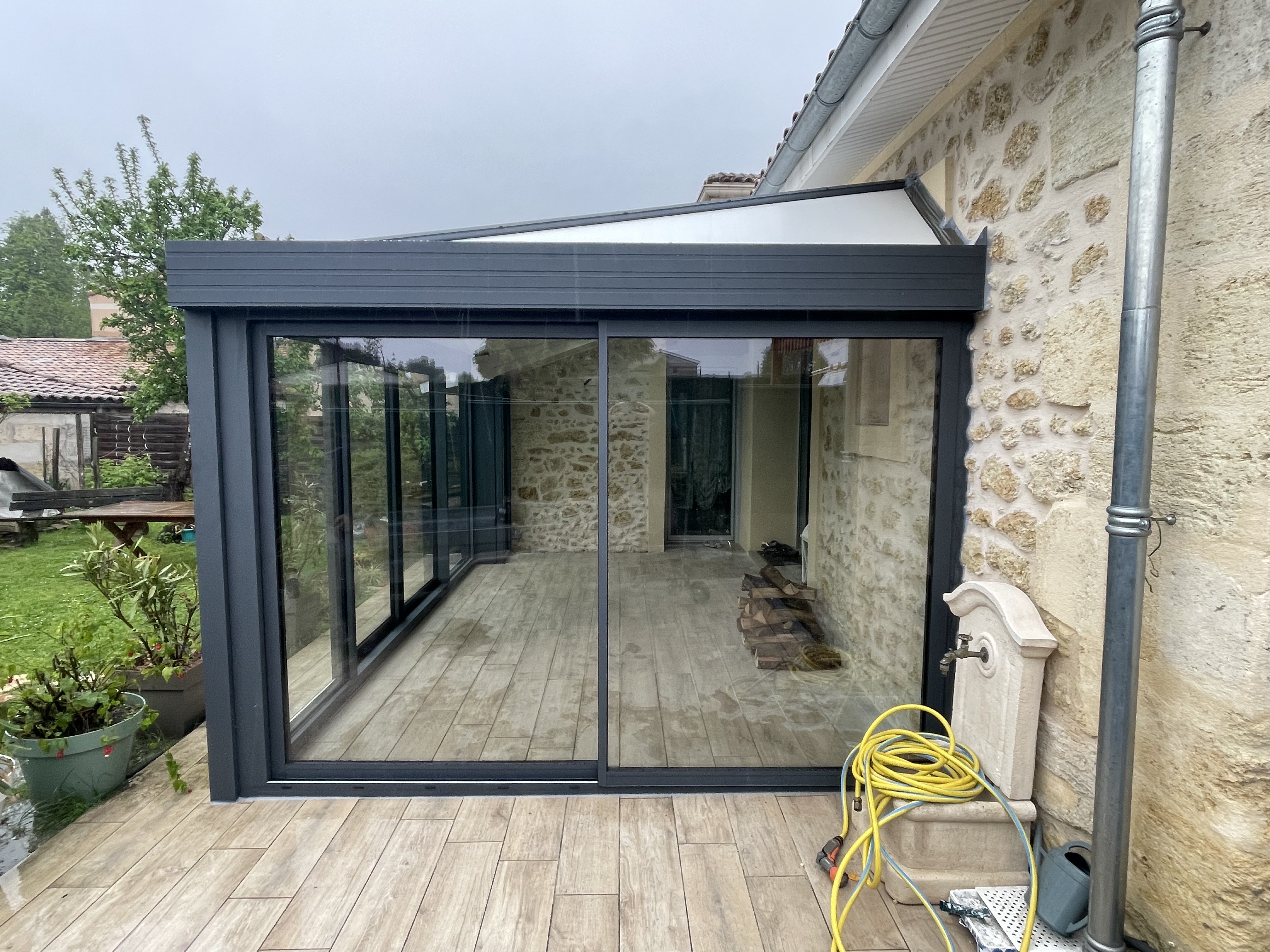 Véranda aluminium adossée maison en pierre